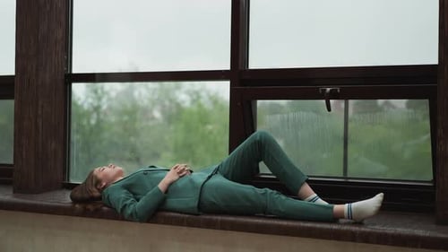 Woman Resting on Window Sill on Rainy Day