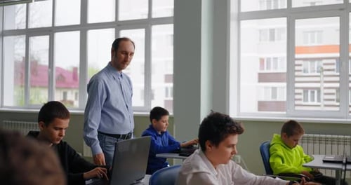 Exam Of Math Or Informatics In ComputerBased Classroom In School Teacher Walking Between Rows