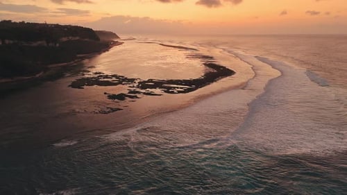 Coastline with Ocean Waves on Low Tide and Sunrise or Sunset Light Drone View