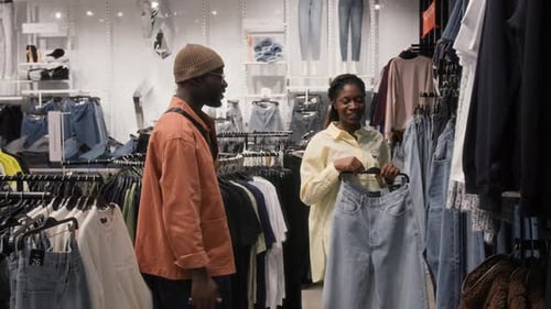 Sales Assistant Consulting Customer Helping to Choose Jeans in Store