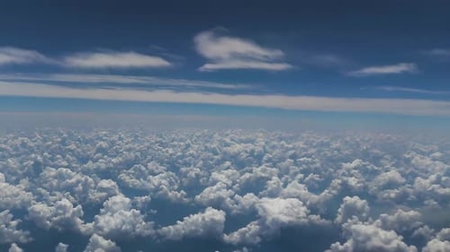 view of airplane cabin, white clouds and blue sky