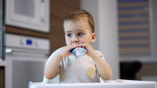 Child Sits in High Chair While Eating Food