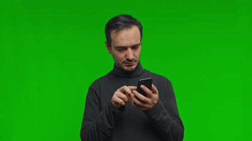 Close Up of Man Using Phone Surfing Texting Message Scrolling on the Green Background