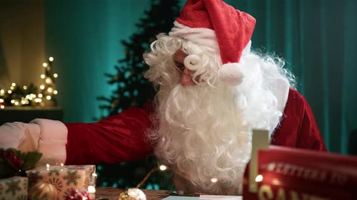 Santa Claus Sorting Gifts Before Christmas at Home