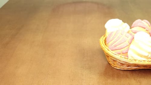 Basket of Colorful Concha Bread on Wooden Table