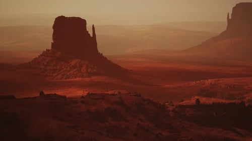 Une majestueuse formation rocheuse dressée au milieu d'un vaste paysage désertique