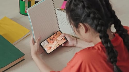 Chica que usa el teléfono en secreto durante la clase