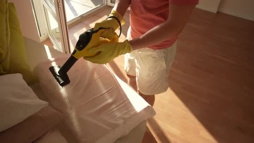 Highangle View of Unrecognizable Janitor Male in Yellow Gloves Cleaning White Orthopedic Pillow on