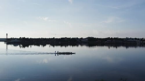 A Row Club practices rowing in the morning during sunrise.