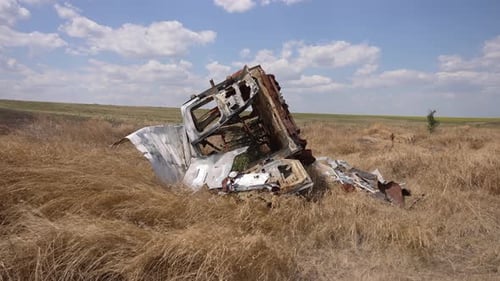 Ein kaputter Traktor auf dem Feld, der vom russischen Feind zerstört wurde