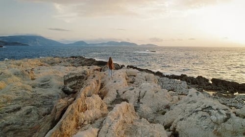 Person exploring rugged rock formations and sea at Alaties beach in Kefalonia