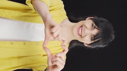 Smiling Woman Makes Heart Shape With Hands