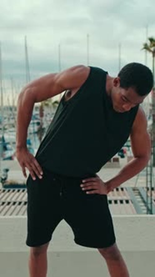 Vertical video, Young Fit Black Man Stretches by Marina