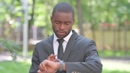 Young Adult Checking Smartwatch in Urban Setting