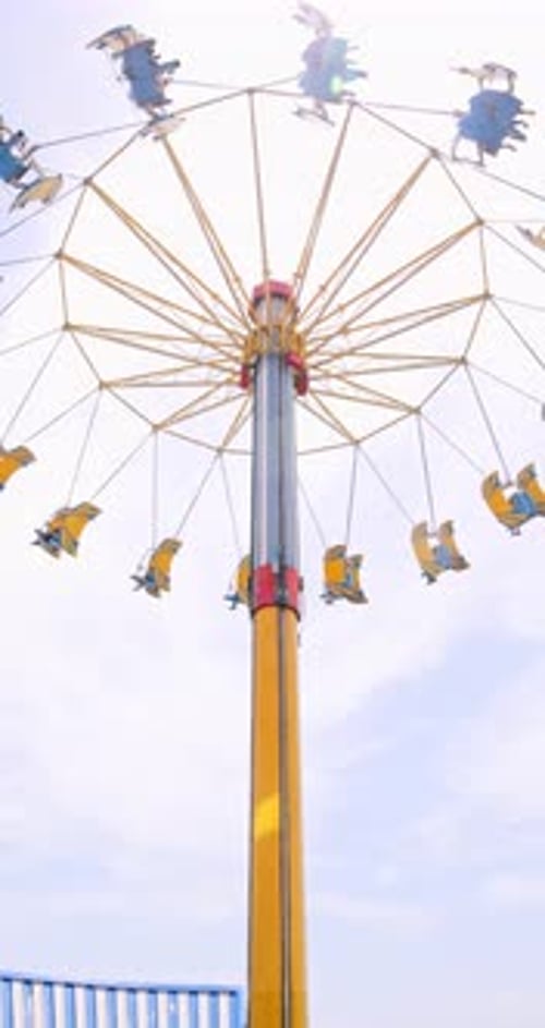 Amusement Park Airplane Swing Ride Against Bright Summer Sky