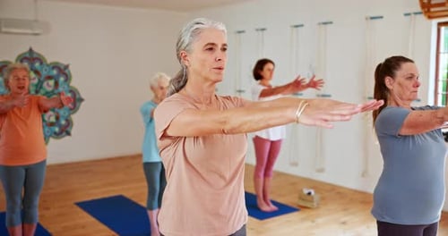 Senior woman, yoga and stretching with class for spiritual wellness or balance together in room