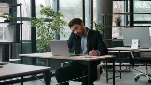 Busy Caucasian Business Man in Office Typing Laptop Talking Mobile Phone Quarrel Professional Male