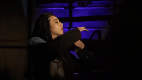 Stylish Woman Dancing in Dark Urban Setting