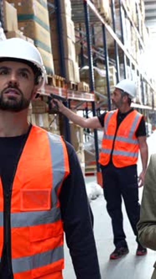 Warehouse Supervisor Showing Inventory to a Businesswoman