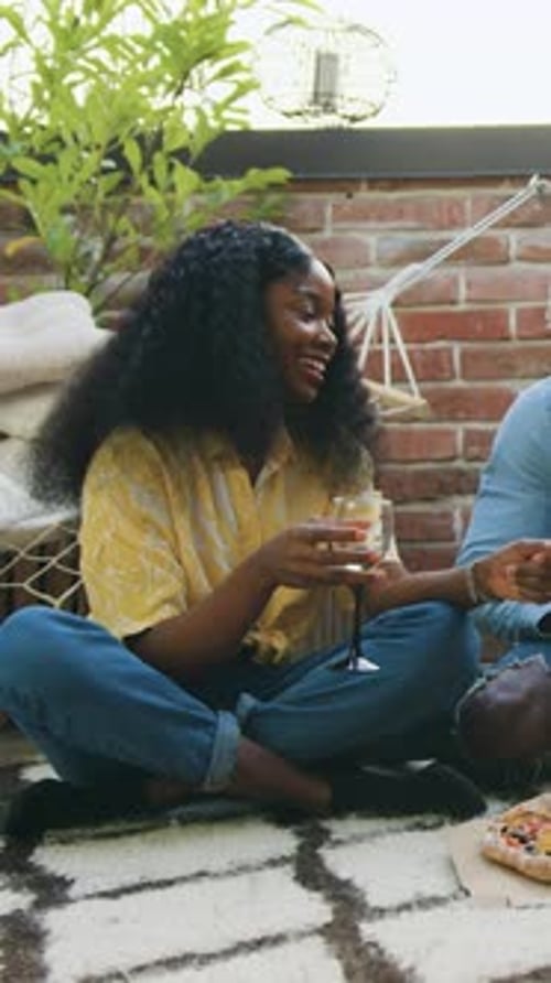 Friends enjoying pizza and drinks on the floor