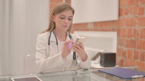 Female Doctor Using Smartphone in Clinic