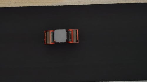 Roller Truck Presses Fresh Asphalt on Road Lane Surface