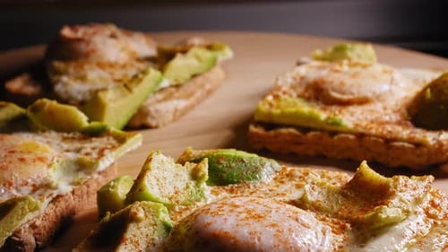 A close up macro shot tilting down to reveal an amazing tasty delicious egg and avocado on toast ope