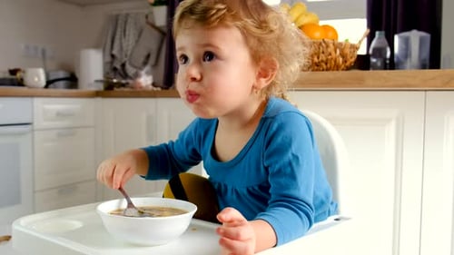 A criança come a sopa do prato
