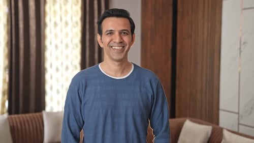 Smiling Man Poses in Relaxed Indoor Setting