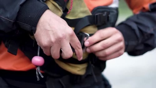 Homme caucasien attachant une combinaison de sécurité avec un harnais avant de partir à l'aventure.
