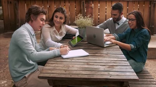 University students study together using technology preparing for exam