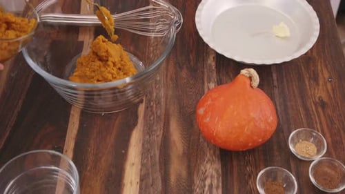 Woman Adding Pumpkin Puree to a Bowl for Autumn Baking