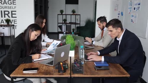 Company Employees in an Open Space Office of Different Nationalities and Genders Work at Computers