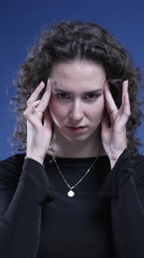 Stressed woman feeling mental pressure by pressing temples with hands trying to relax