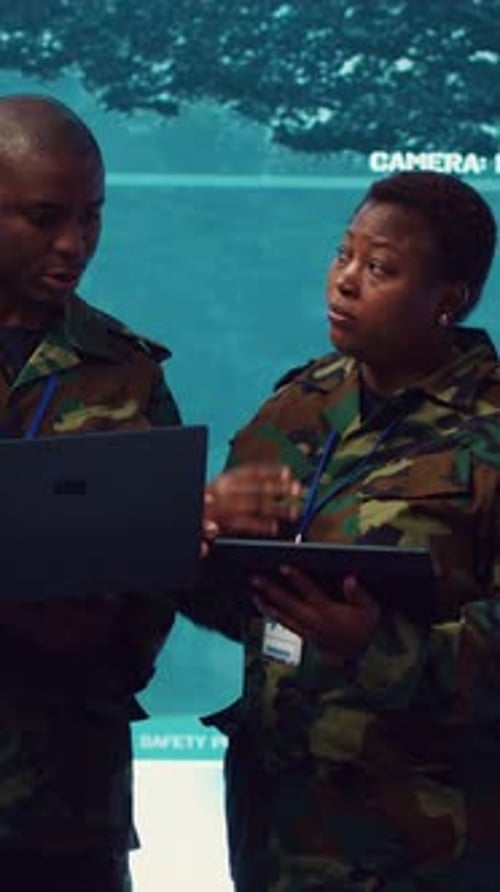 Man and Woman in Uniforms Analyze Military Data