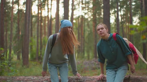 Happy Cousins Relaxing on Fallen Tree in Peaceful Forest