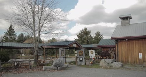 Beautiful entrance to a wedding farm venue with a covered walk way, white rustic doors and a chapel