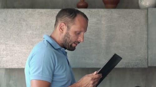 Man using tablet device in a kitchen setting