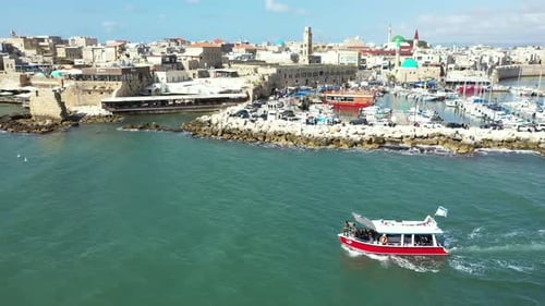 Luftbild: Rotes und weißes Boot segeln neben der Altstadt von Acre