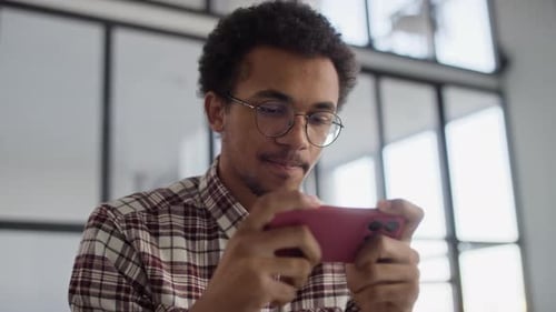 Young Adult Plays Game on Smartphone