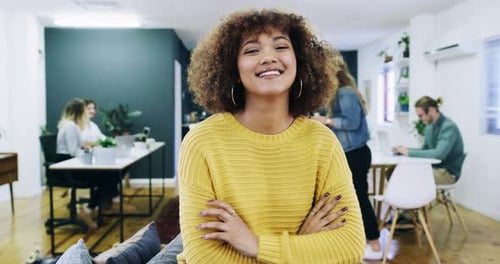 An attractive young businesswoman standing with her arms crossed in the office