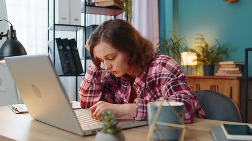 Bored Sleepy Businesswoman Worker Works on Laptop Computer Yawns Leaning on Hand at Home Office Desk
