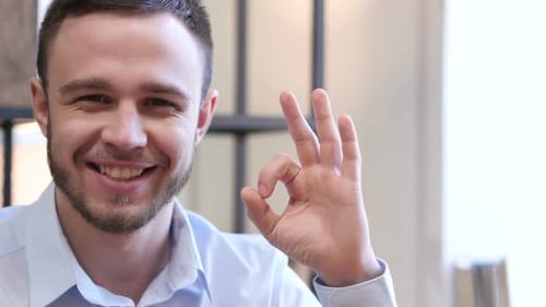 Smiling Man Gives Ok Hand Gesture