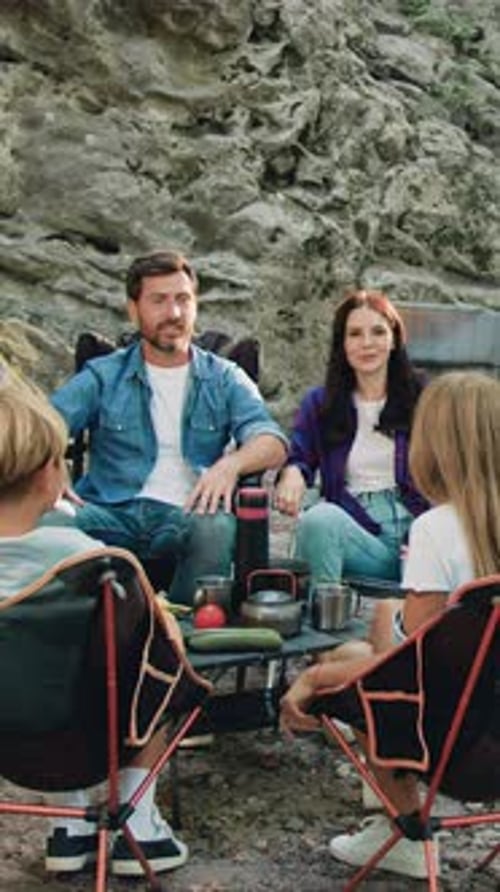 Happy Family Including Mother Father and Two Kids Enjoying Summer Holidays in the Garden or Park