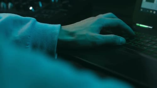Professional Hacker Typing on a Laptop Keyboard