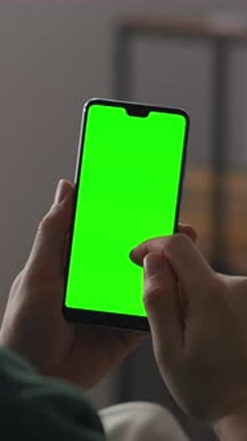 Closeup of a Person Holding a Modern Smartphone with Vivid Green Chroma Key Display Ready for