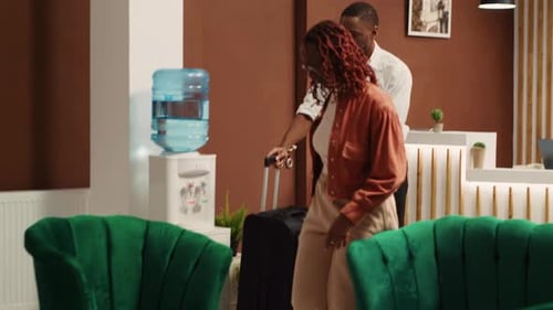 Couple Checking in at Hotel Reception Desk