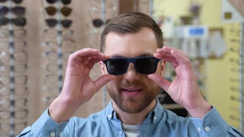 Portrait of Handsome Bearded Guy Picking New Sunglasses at Optical Shop