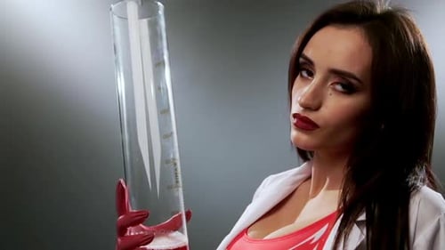 Woman Scientist Holding Cylinder with Red Liquid