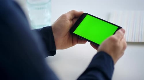 Unrecognized businessman reading message on smartphone with green screen technology